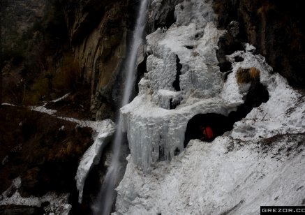 Secret passage under the waterfall. Frozen waterfall